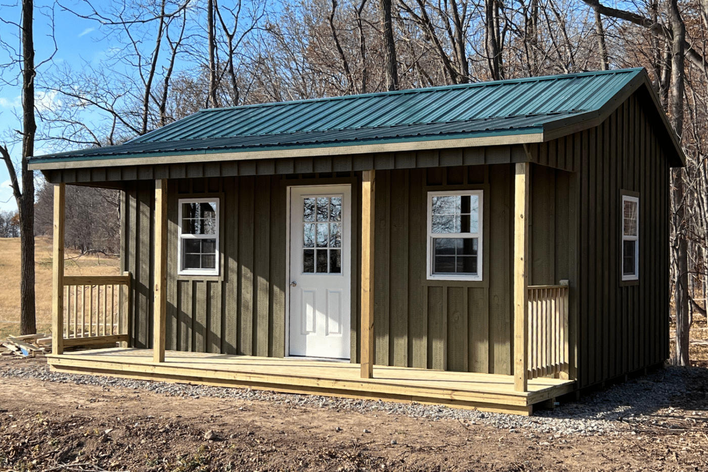 brown 12x14 cabin with side porch and green metal roof in new york
