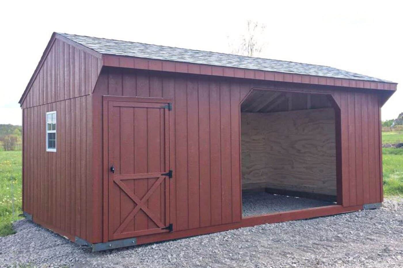 Dark red run in shed with white-framed window-on gravel-green grass near background